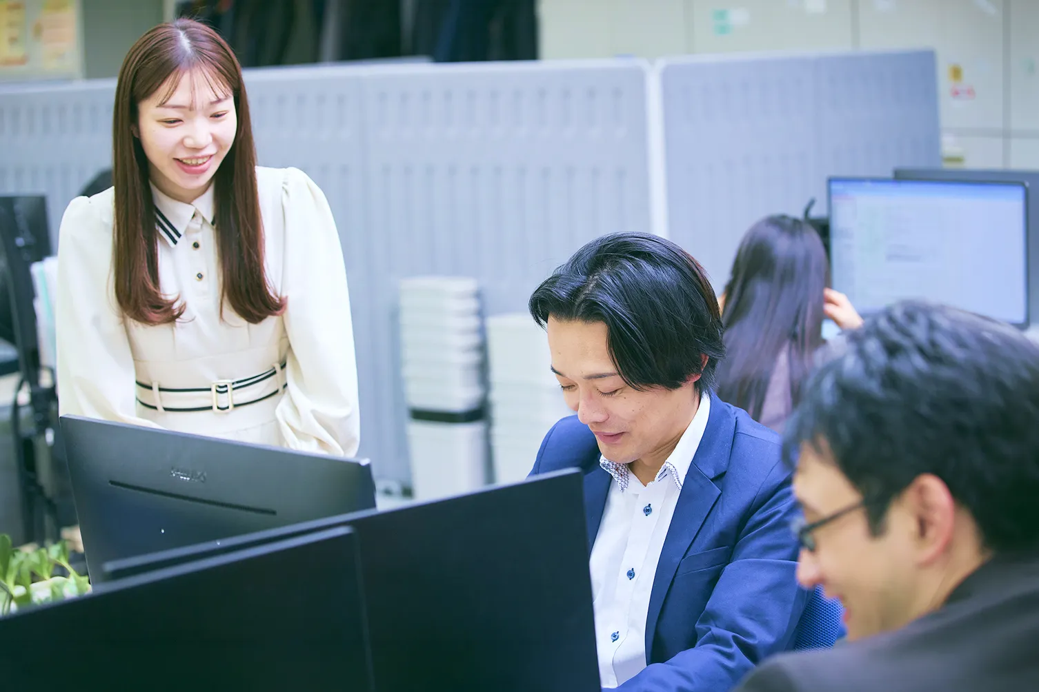 アプリケーションエンジニア G.H.さんとアプリケーションエンジニア M.F.さんがデスクで話をしている写真