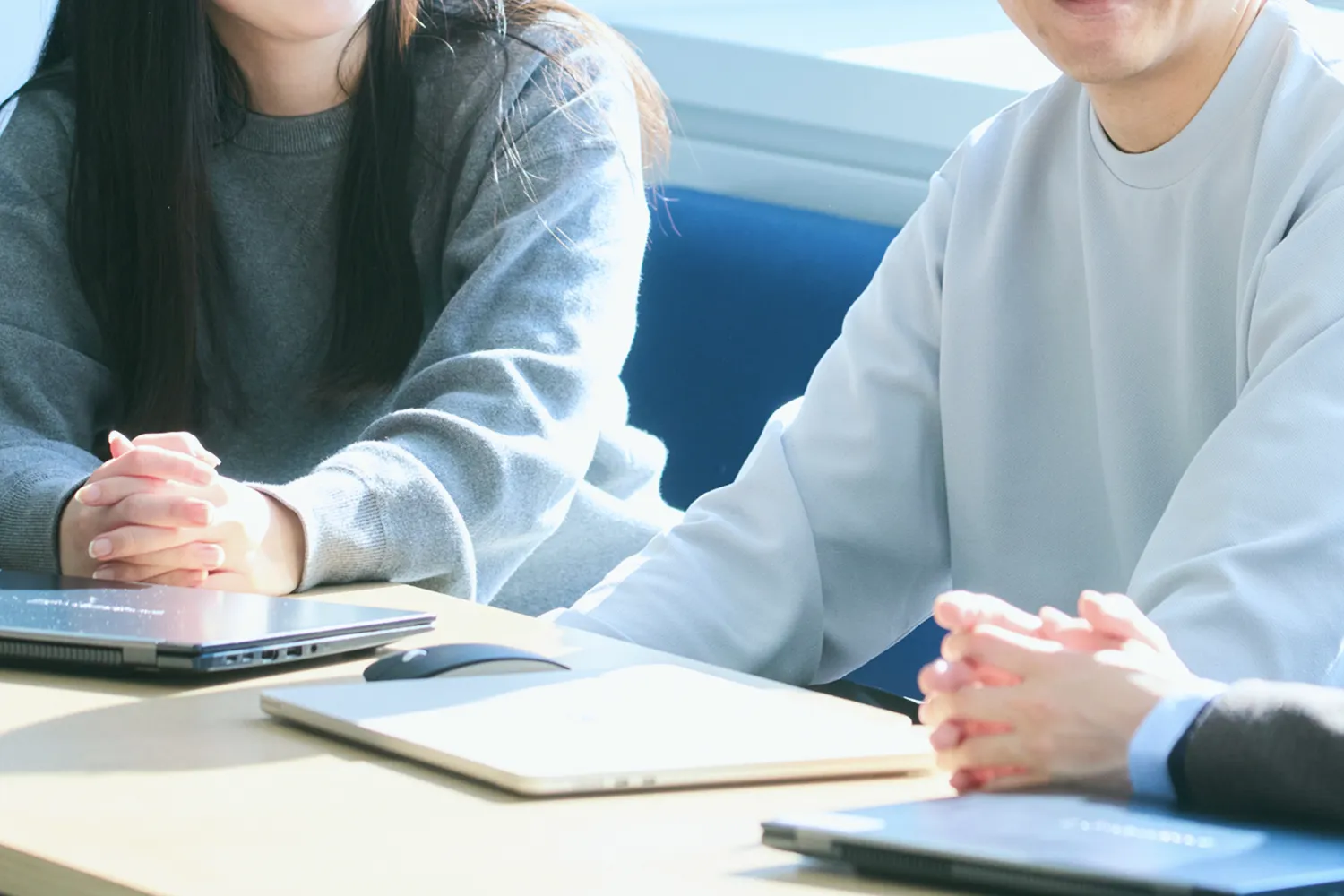 男性社員2人と女性社員1人が打ち合わせしている写真